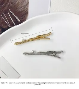 Detail shot of wavy gold and silver hair clips with pearls and 8cm size specification