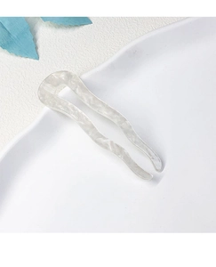 Detail showing wave-shaped cream acetate U-shaped hair pin with marble texture