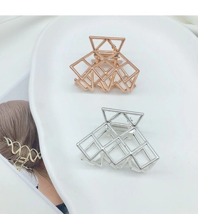 Dettaglio di pinze per capelli geometriche traforate in argento e oro rosa per stile elegante