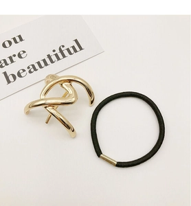 Close-up of golden minimalist hair clip and black elastic ponytail holder set