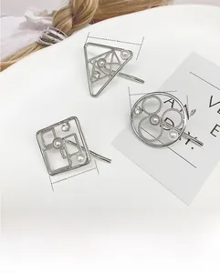 Detail view of silver geometric hair clips with inlaid pearls and rhinestones
