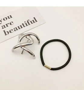 Close-up of minimalist silver metal knot hair cuff and elastic band on white background