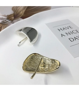 Detailed close-up of metallic ponytail hair hooks in silver smooth and gold hammered textures