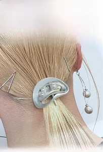 Nahaufnahme der silbernen gewellten Haarspange mit Perlen auf blondem Haar im Minimal-Stil