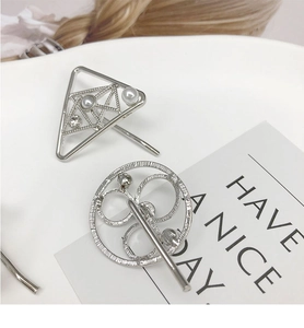Detailed macro view of silver geometric hair clips with pearls and rhinestones decoration