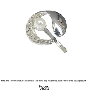 Detail of silver hammered metal hair hook with central white pearl and curved fringe design