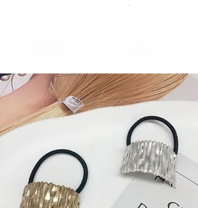 Detail of metallic hair ties with textured wave pattern in gold and silver finishes