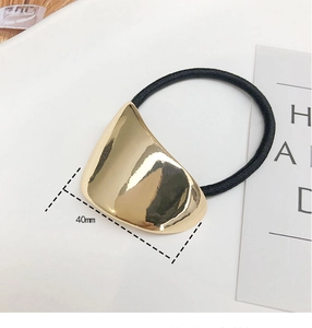 Detail shot of golden crescent metal hair tie with 40mm size measurement