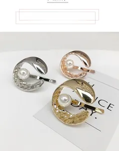 Detailed view of round metal hair hooks with pearls in gold, silver, and rose gold finishes
