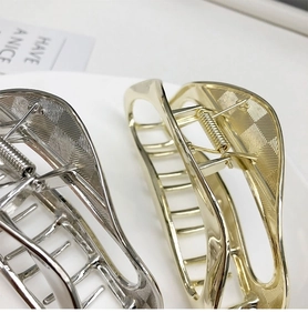Detail view of large metal shark hair clips with rhombic texture and strong spring
