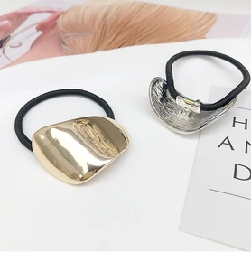 Close-up of gold and silver irregular metal hair ties with glossy mirror finish