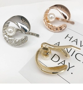 Detailed view of C-shaped metal hair clips in gold, silver and rose gold with pearls