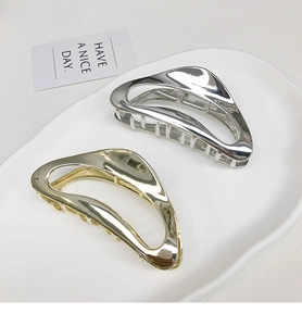 Macro detail of metallic shark hair claws in gold and silver with a hollow design