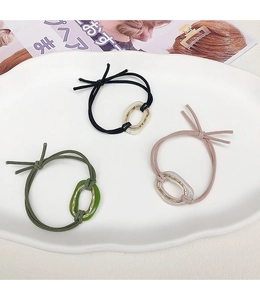Close-up of three high-elastic hair ties with acrylic and gold metal buckles on a white plate
