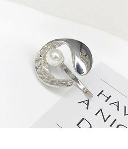 Detailed view of silver hair hook with hammered metal texture and large white pearl