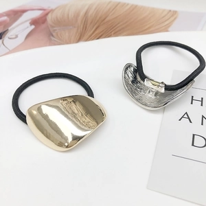 Elastic hair ties with gold and silver geometric metal accents on minimalist black bands