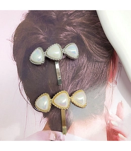 Detail of elegant gold and silver hair hooks with heart-shaped iridescent stones