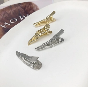 Detailed view of wave-shaped alloy hair clips in gold and silver with non-slip texture