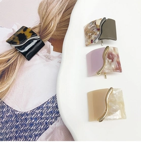 Close-up of square leopard resin hair clips in four elegant marbled color combinations