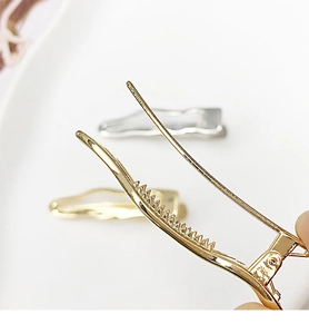 Close-up of wavy metal hair clip showing non-slip sawtooth design and silver plating