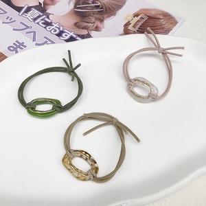 Three-piece set of minimalist acetate elastic hair ties in green, purple, and amber marble