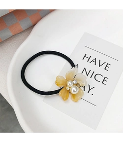 Detalle de coletero floral con pétalos de resina ámbar y perlas blancas incrustadas
