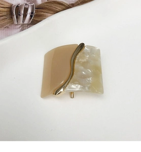 Detail of square leopard resin hair clip with gold metal wave and marble pattern