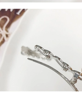 Vue détaillée du mécanisme à ressort et de la charnière de la pince à cheveux en argent