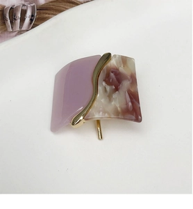 Detailed macro view of retro square resin hair clip with purple and amber pattern finish