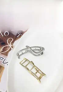 Détails des pinces à cheveux géométriques en or et argent sur un plateau décoratif