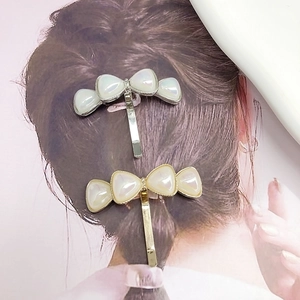 Elegant bow-shaped ponytail hair hooks in gold and silver finish with pearl resin inlay