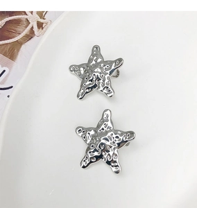 Détail des barrettes étoiles argentées avec texture en métal martelé et finition élégante