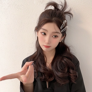 Minimalist silver wavy metal hair clips set worn by a model in a black suit