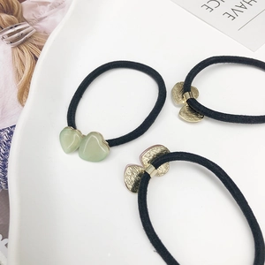 Élastiques à cheveux avec breloques double cœur vert clair dans un plat en céramique
