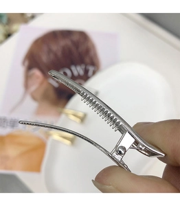 Vista macro del fermaglio per capelli argento con design interno a dente di sega