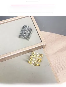 Detailed view of multilayer wavy metal ear cuffs in polished gold and silver finishes