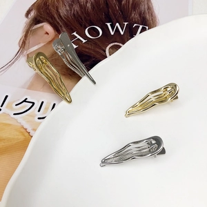 Elegant gold and silver wave hollow hair clips set on a stylish fashion magazine