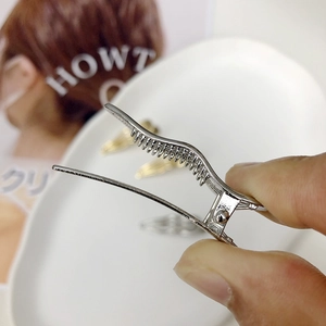 Silver wavy metal hair clip with anti-slip teeth shown in a high-quality detail view