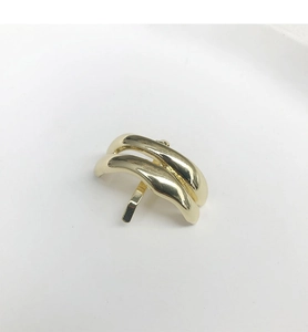 Vue détaillée d'une épingle à cheveux en métal doré poli au design incurvé double couche