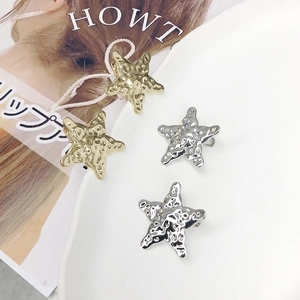 Barrettes en forme d'étoile dorée et argentée avec une surface en métal texturé lave