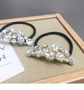 Dettaglio ravvicinato di elastici per capelli con strass in oro e argento