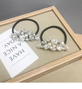 Dettaglio di elastici per capelli con ornamenti in strass lucidi dorati e argentei