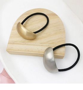 Detail view of elastic hair rings with gold and silver metallic semi-circular accents