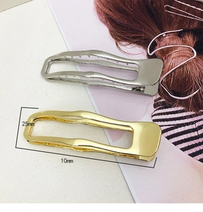Detail view of hollow rectangular metal hair clips in gold and silver showing 25mm dimensions