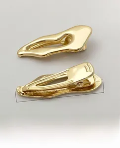 Detail view of a 53mm gold metal alligator hair clip with polished electroplated finish