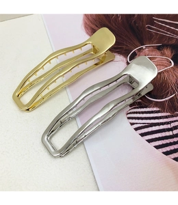 Detail showing polished gold and silver metal hair clips with hollow streamlined design