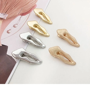 Detailed close-up showing irregular lava-style metal hair clips in gold and silver finishes