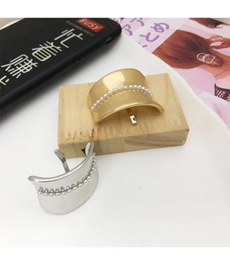 Detailed view of elegant pearl-inlaid metal hair clips in gold and silver finishes