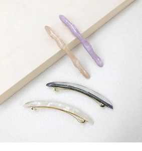 Detailed set of four acetate hair clips in wavy and crescent shapes with marble patterns