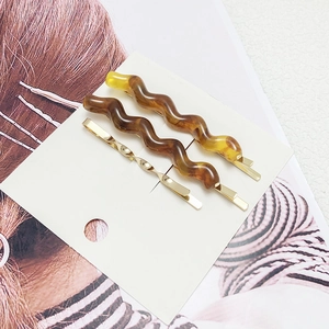Set of 3 elegant wavy amber acetate hair clips and twisted gold metal hairpins on card
